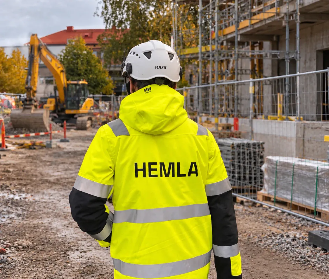 En person från HEMLA i hjälm och varseljacka på en byggarbetsplats
